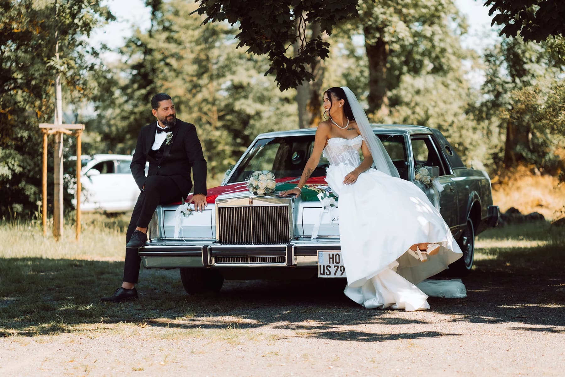 Brautpaar am Oldtimer mit türkischer und portugiesischer Flagge — türkisch-portugiesische Hochzeit in Hof
