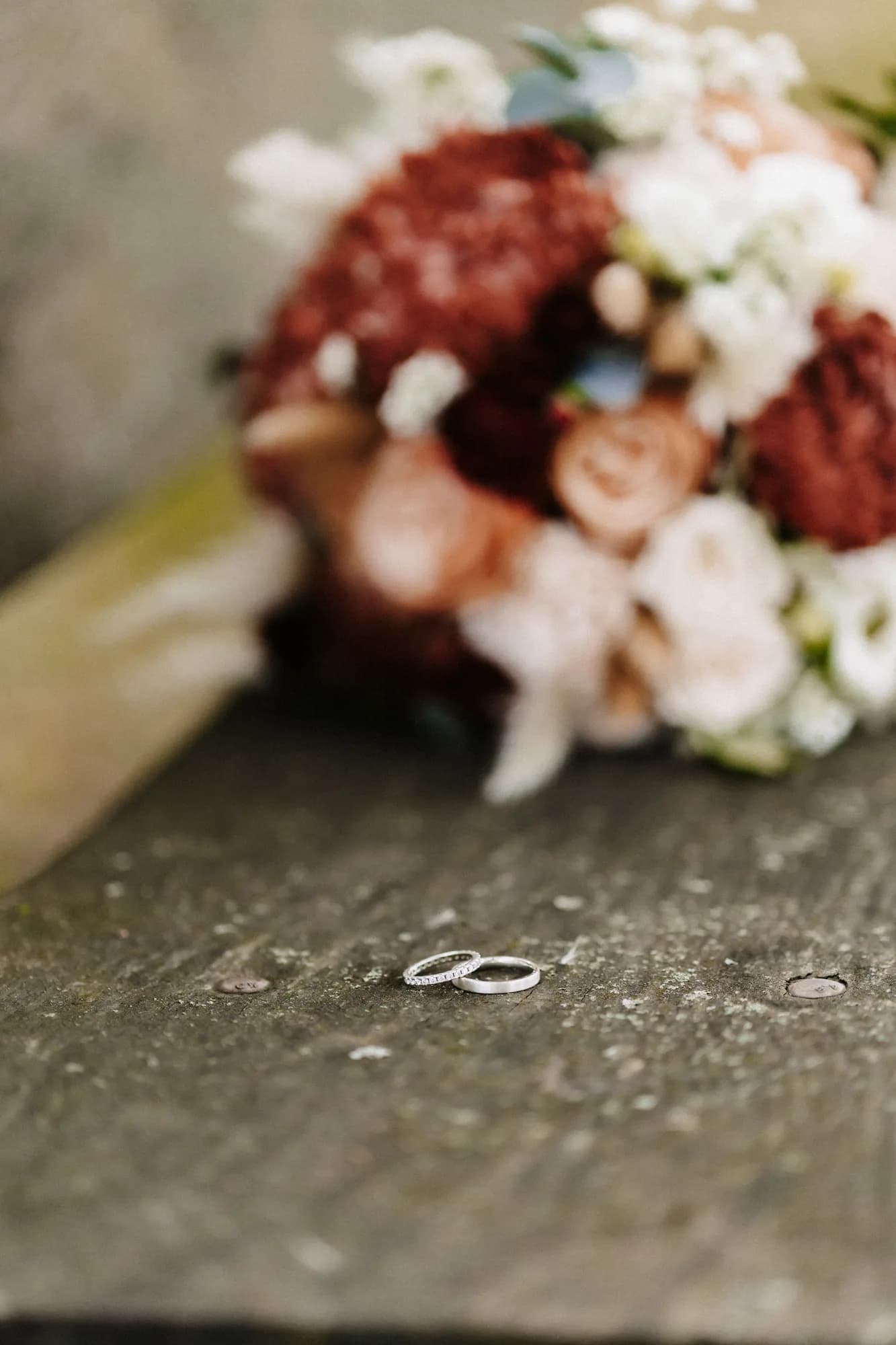 Eheringe auf Holz vor dem Brautstrauß — Detailfoto Hochzeit Gasthof Schimmel, Steinbühl bei Berg