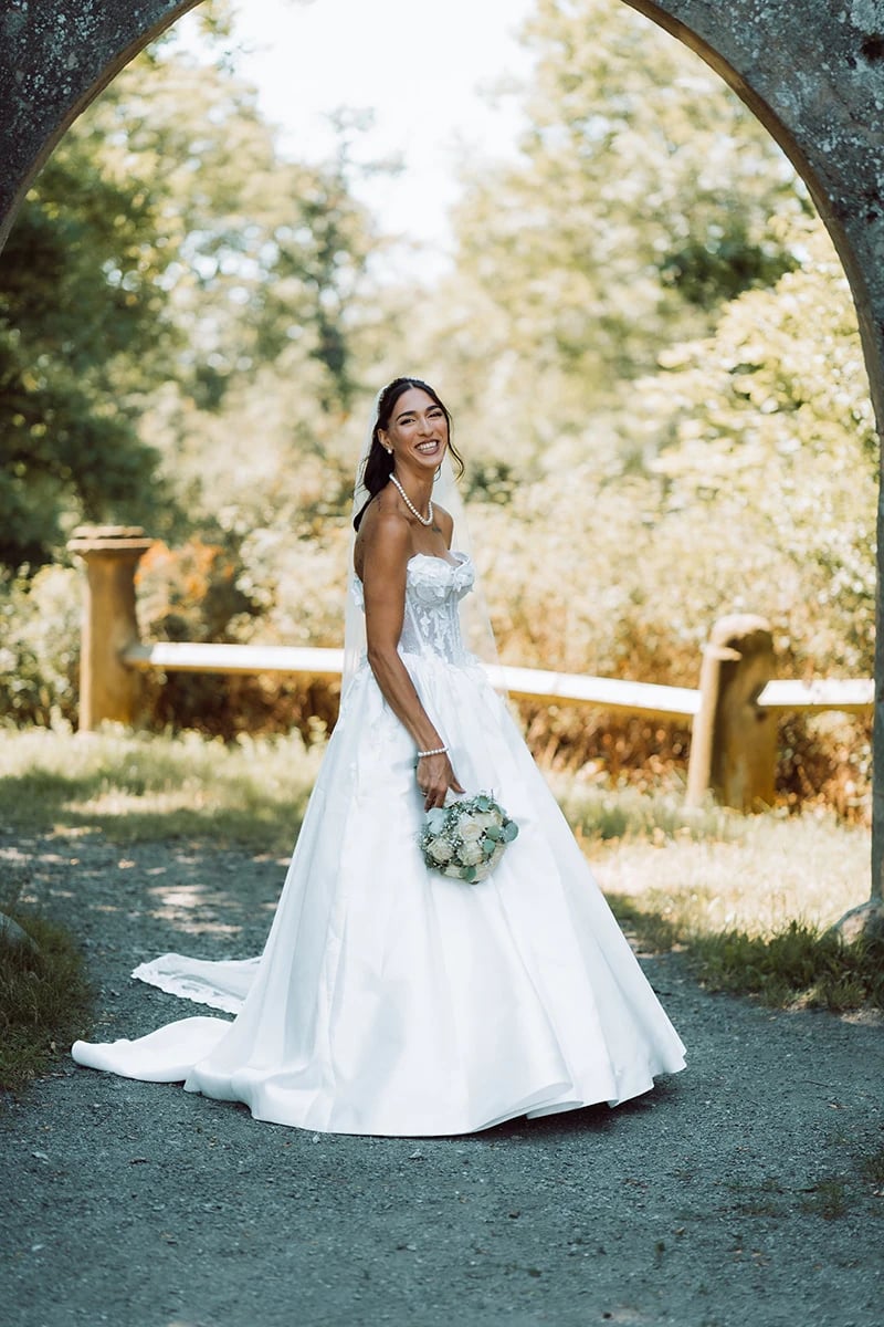 Lachende Braut im Ballkleid unter dem Steinbogen der Burgruine — Hochzeitsfotografie Theresienstein, Hof