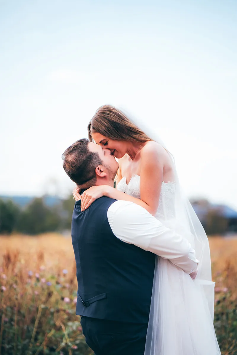Bräutigam hebt die Braut auf einer Wiese hoch — Hochzeit in Schwarzenbach am Wald, Oberfranken